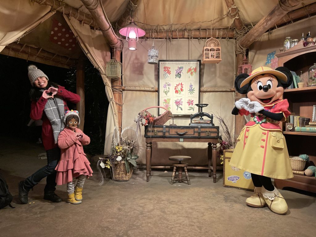 Jelly and her daughter meet Minnie Mouse, who is donning a yellow and pink safari outfit and hat.