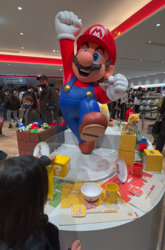 A large sculpture of Super Mario with his hand raised sits in the middle of the Nintendo Store in Shibuya.