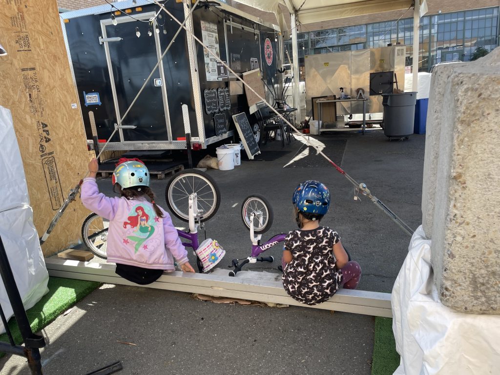 Two children playing with their woom 3 and woom 1 bikes upside down in Richmond California