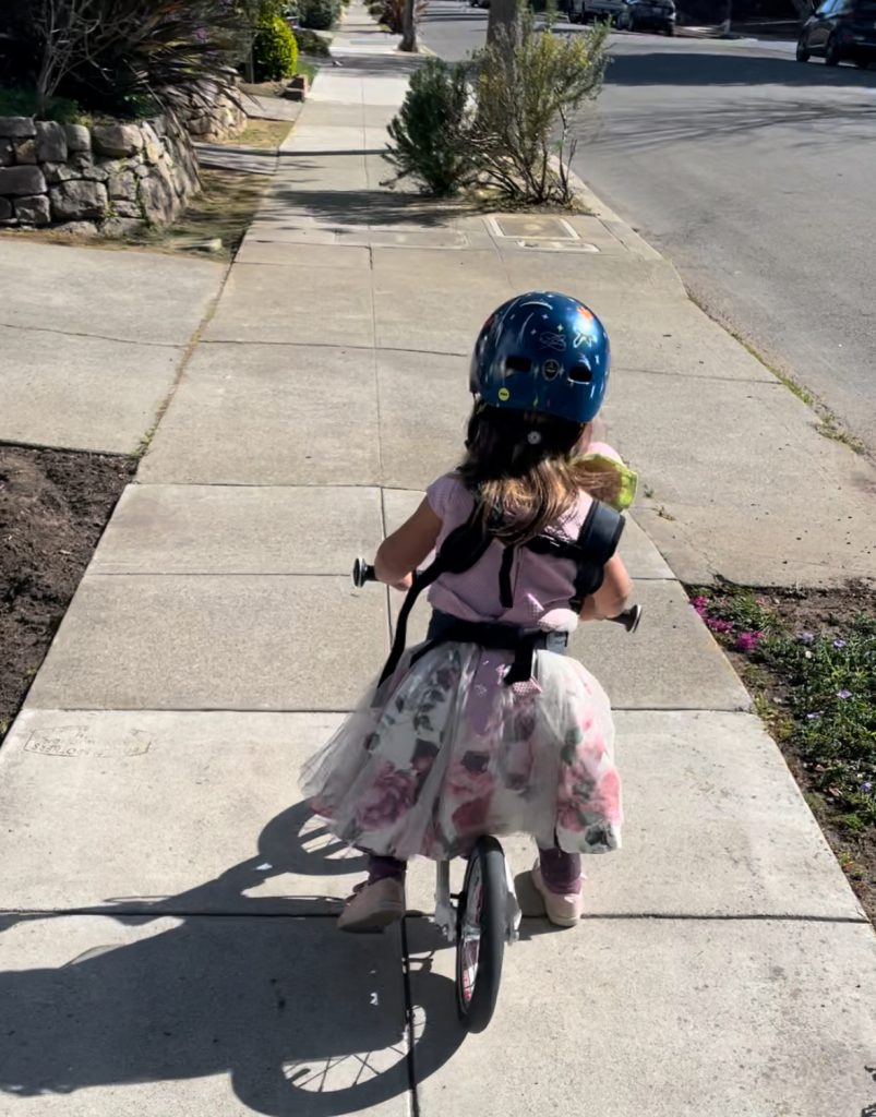 A child on a woom 1 balance bike in a dress