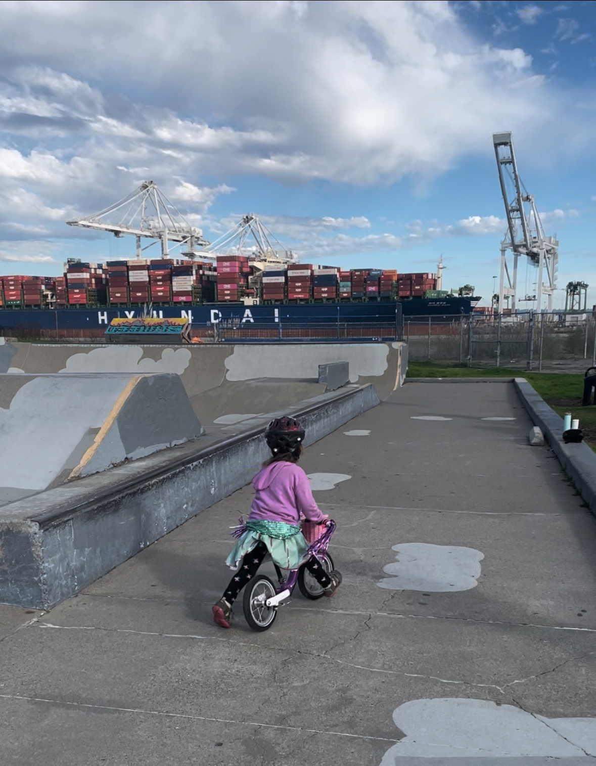 A child riding a purple woom 1 balance bike at Alameda Skate Park