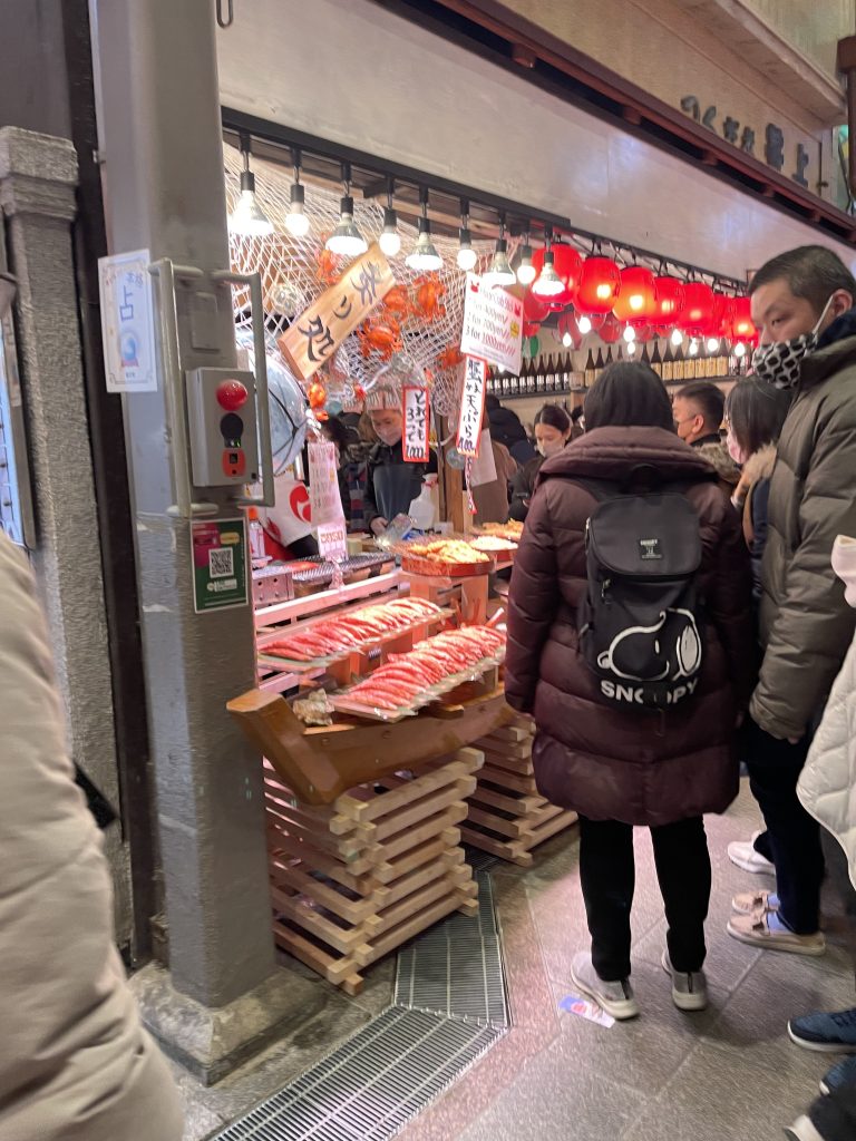 Passersby stop at a stall selling food.