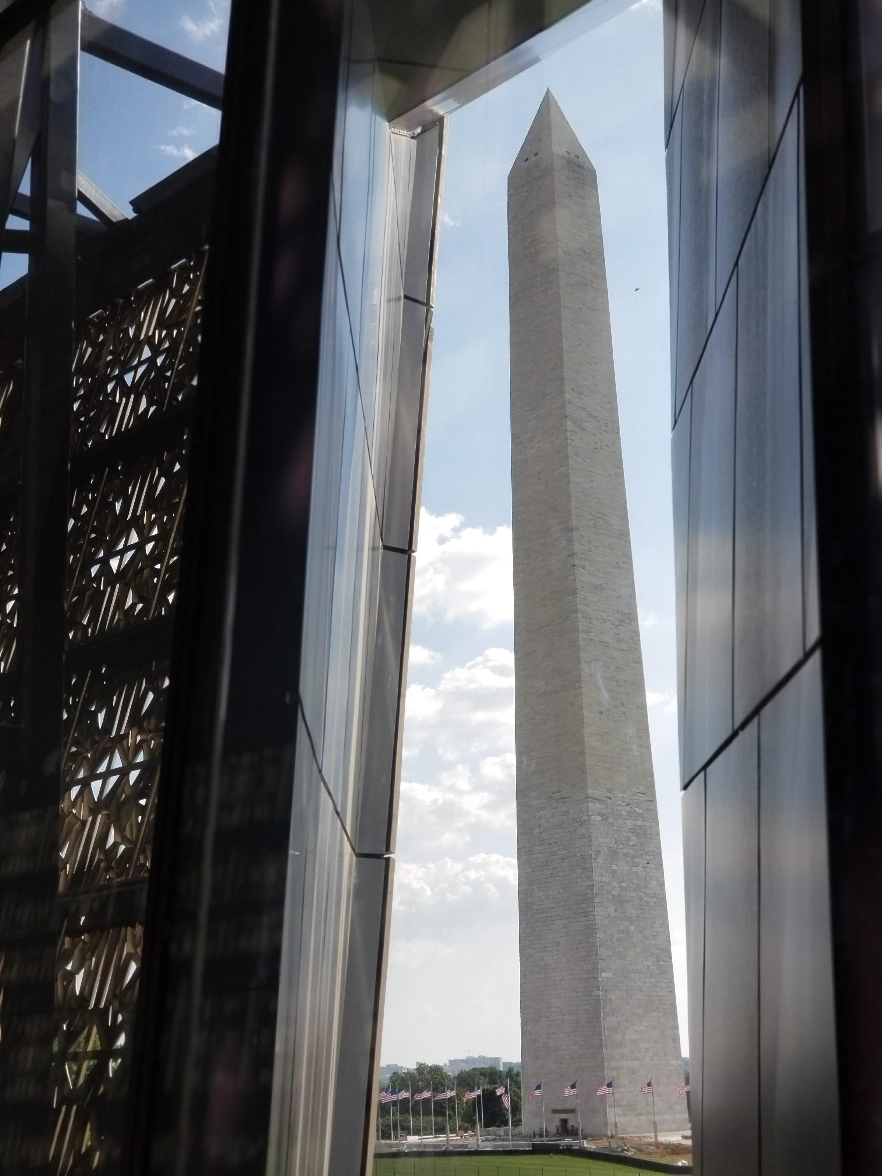 The obelisk of the Washington Monument is framed by a dark-framed window.