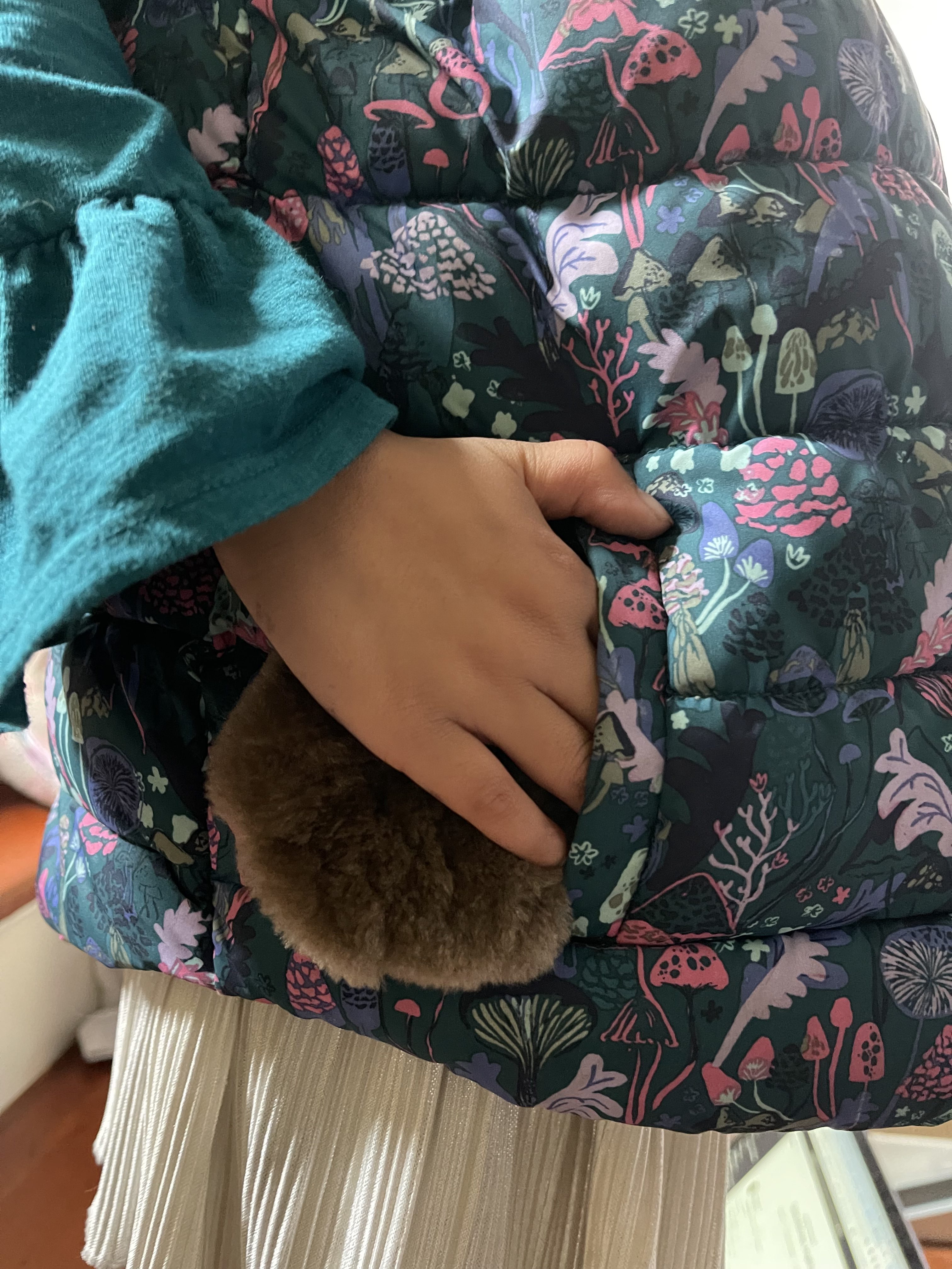 A child putting a small beaver pelt hand warmer in her pocket from Aurora Heat