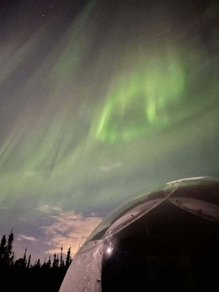 Swirl of northern lights above an igloo at Borealis Basecamp in Fairbanks Alaska