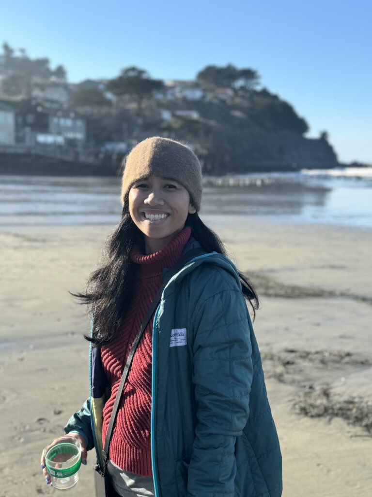 A woman wearing a muskox headband on a beach in Pacifica, California during king tide