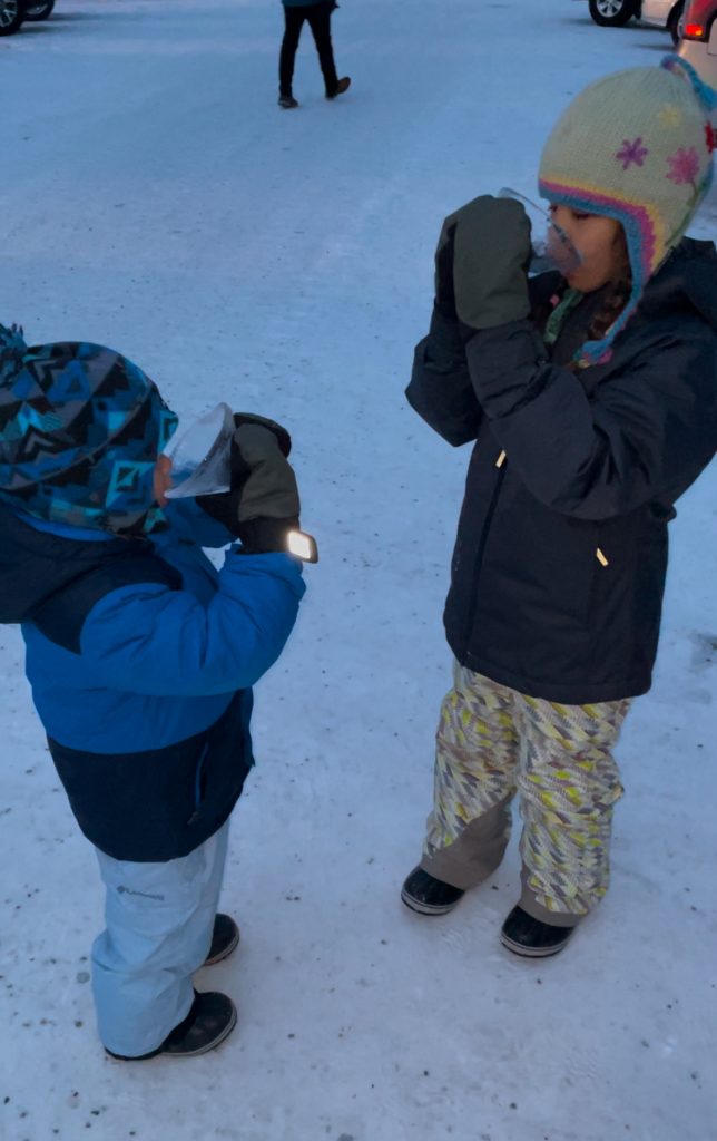 Two children with ice martini glasses from the ice museum at Chena Hot Springs near Fairbanks, Alaska