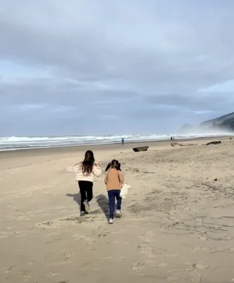 Two children running on the beach in Lincoln City OR