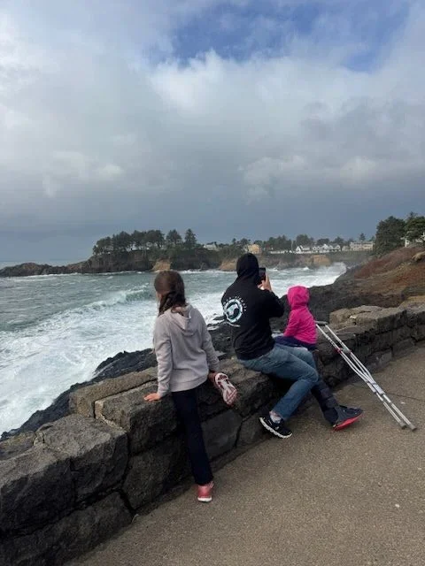 A family taking pictures near a blow hole at Depoe Bay, OR