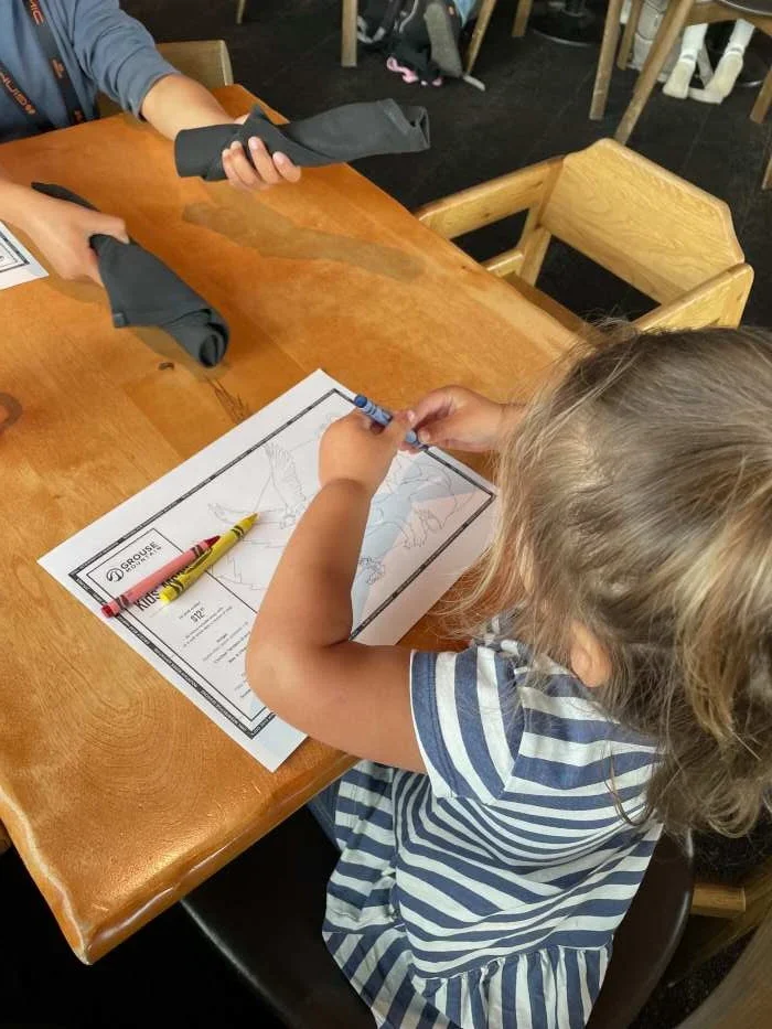 A child with a coloring page at Lupins Cafe at Grouse Mountain Vancouver Canada
