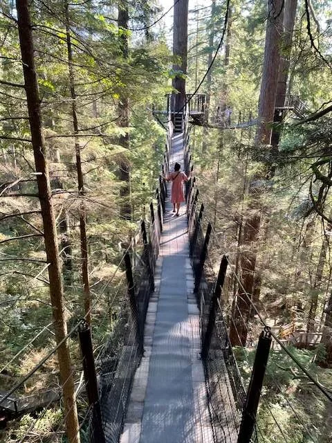 Mother walking the Capilano Suspension Bridge Park Treetops Adventure with her child in Vancouver, Canada