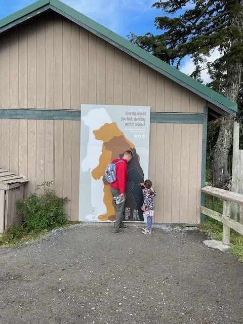 Adult and child measuring their height at Grouse Mountain Vancouver Canada
