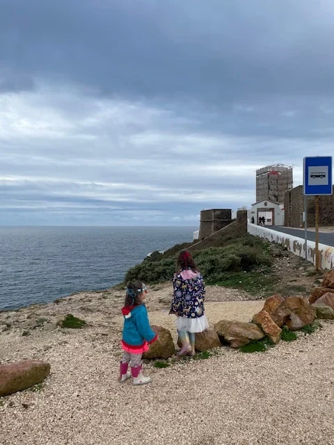 Two children looking at the Sagres lighthouse under construction