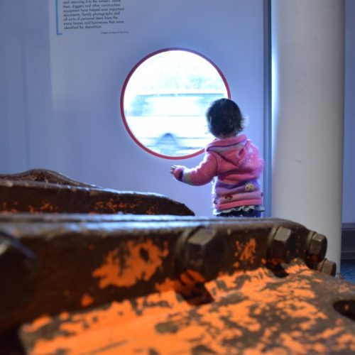 A child peering through a window at the Quake Museum in Christchurch, NZ